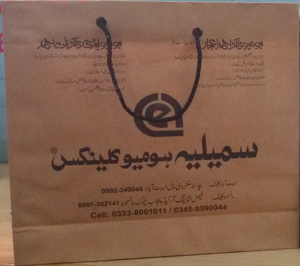 A brown paper Similia Homoeo Clinix bag with the names of both founders and the Abbottabad and Mansehra clinics